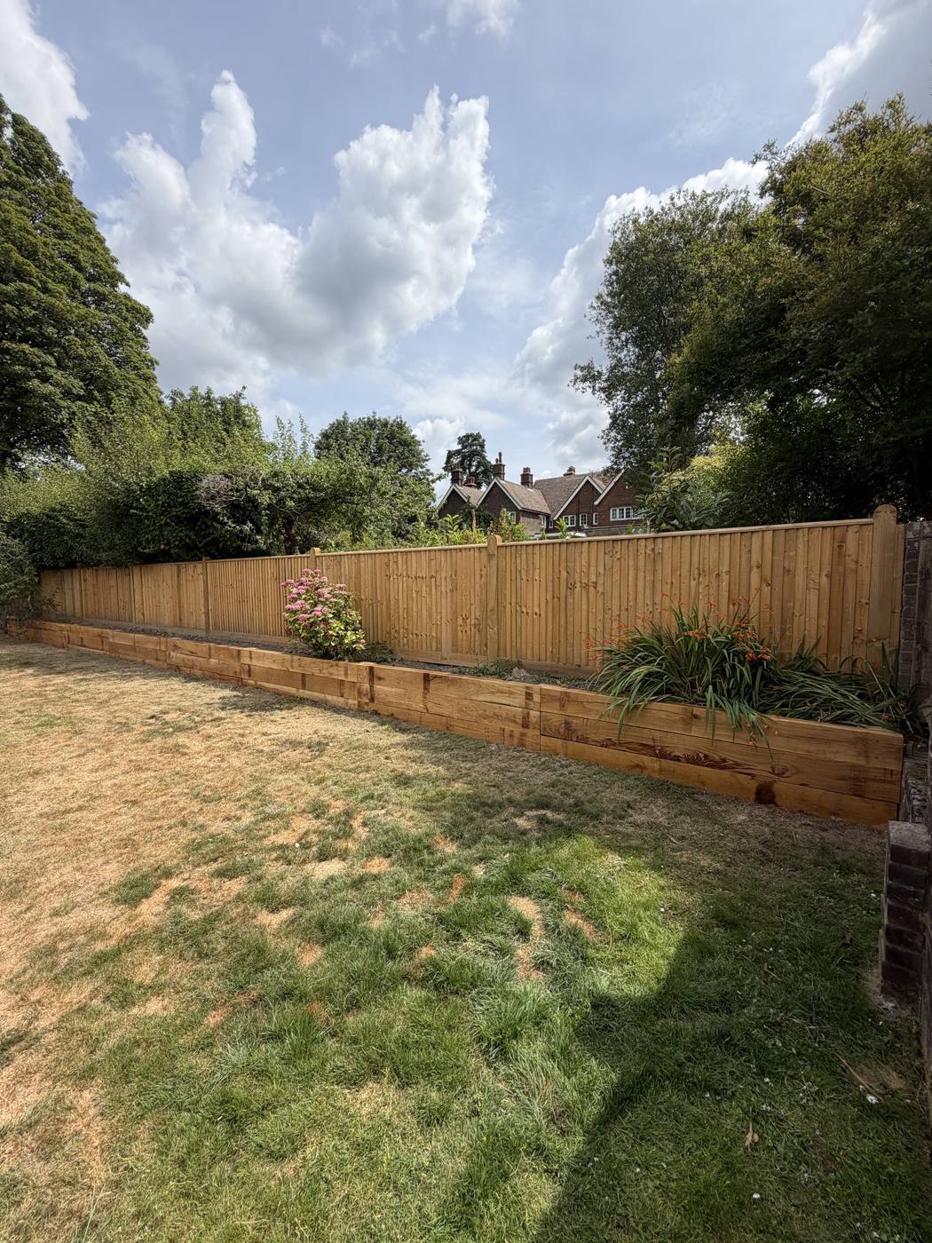 Close board fence above a sleeper raised bed