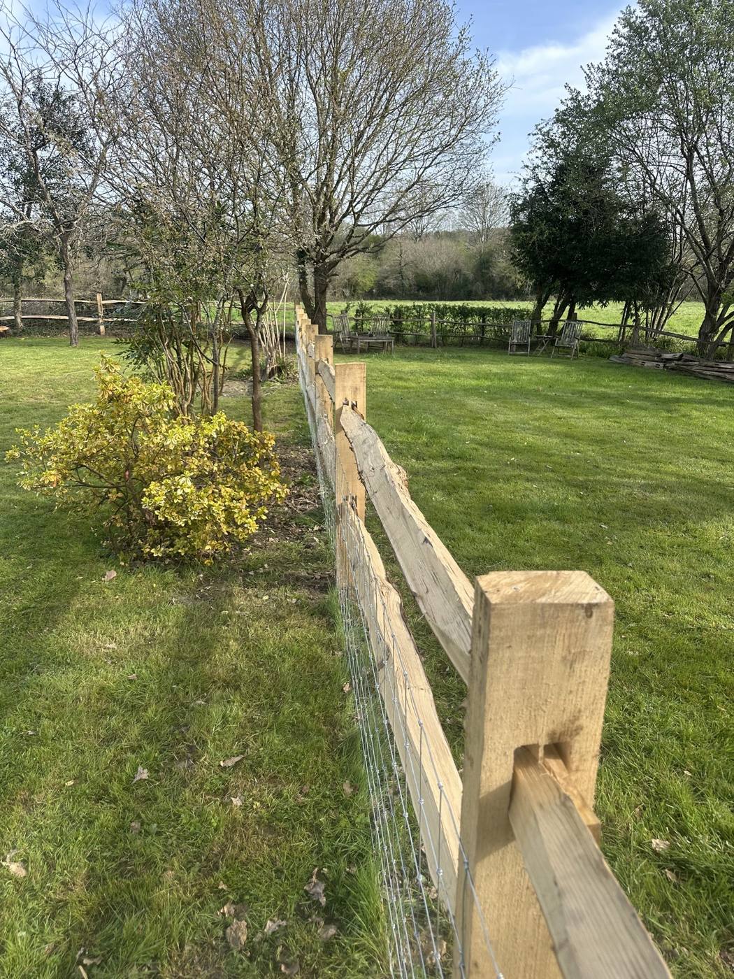 Post and rail fence across a lawn
